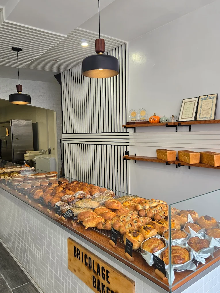 Interior of Bricolage Bakery with glass pastry case and geometric wall pattern